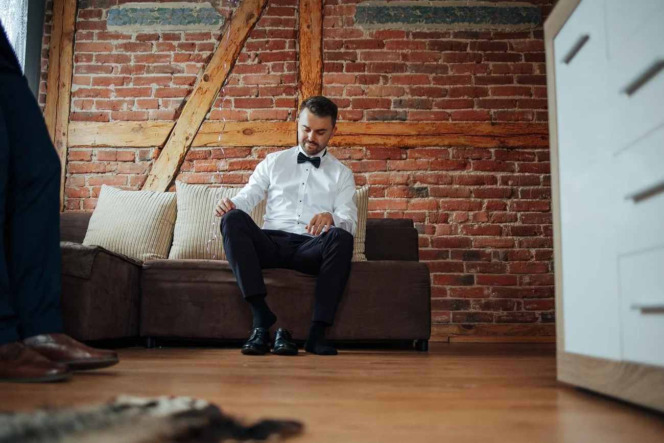 Przygotowania - pan młody zakładający buty