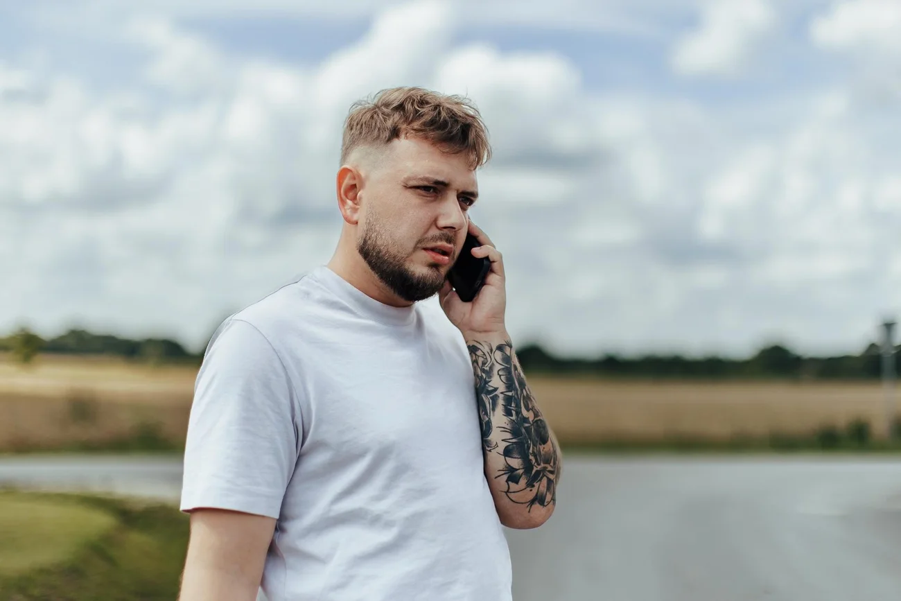 Pan Młody rozmawia przez telefon przed przygotowaniami do ślubu - fotograf ślubny Sulmierzyce