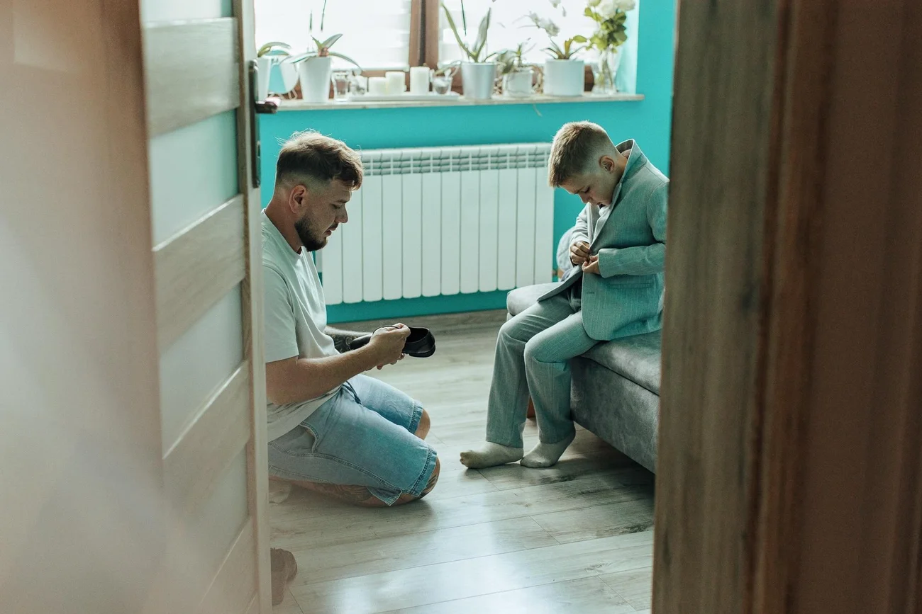 Pan Młody zakłada but synowi - fotograf ślubny Sulmierzyce