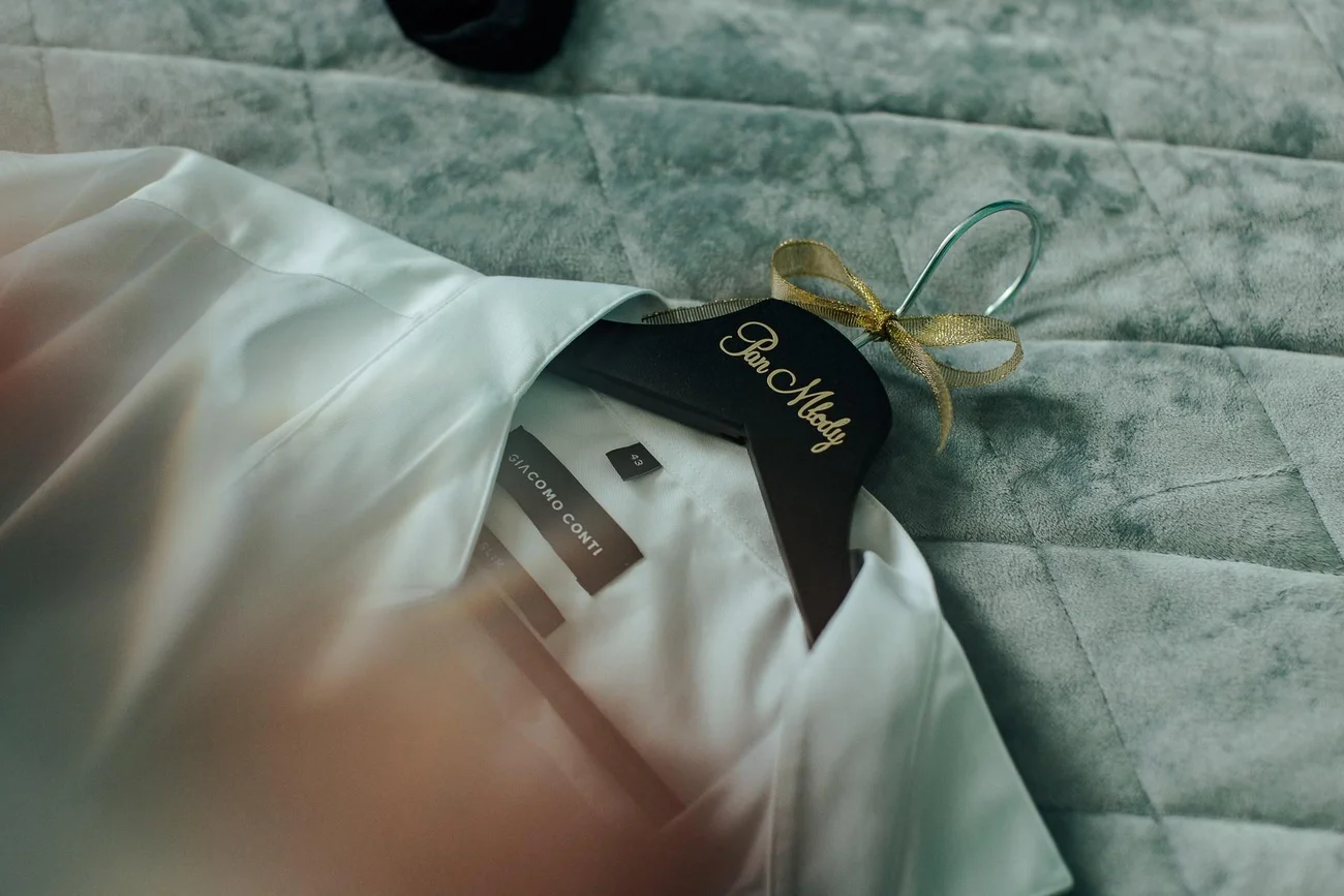 Detal marynarki Pana Młodego na wieszaku - elegancka stylizacja ślubna