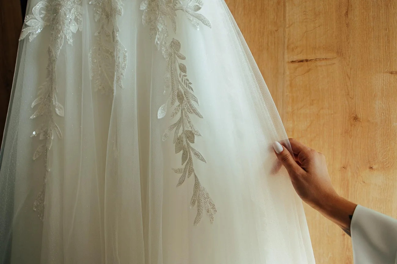 Detal koronki sukni ślubnej trzymanej przez Pannę Młodą - fotograf ślubny Sulmierzyce