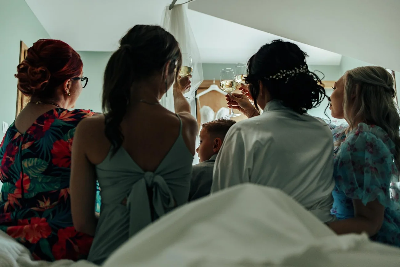 Druhny i rodzina wznoszą toast z Parą Młodą - reportaż ślubny